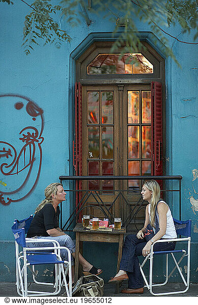 Two friends talk over a beer in Buenos Aires  Argentina.