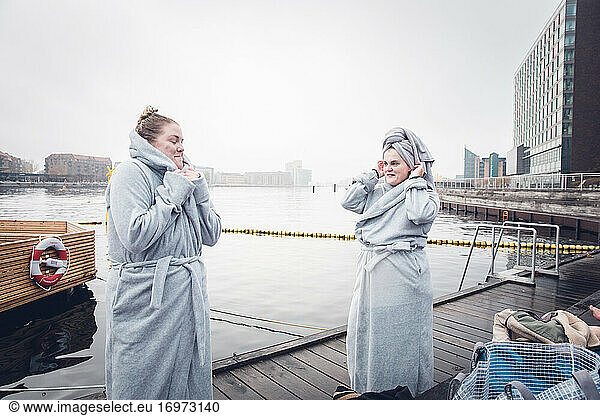 Two Friends Wearing Matching Robes After Cold Swim in Denmark