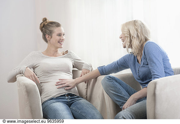 Two friends women young pregnant talking chair