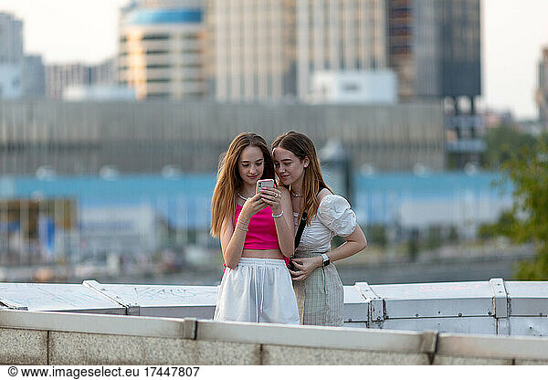 two girls are looking at the phone