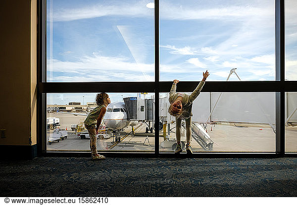 two girls bored and playing in airport waiting to board plane