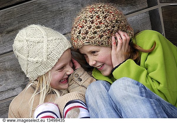 Two girls  friends  laughing and whispering  Emmendingen  Baden-Wuerttemberg  Germany  Europe