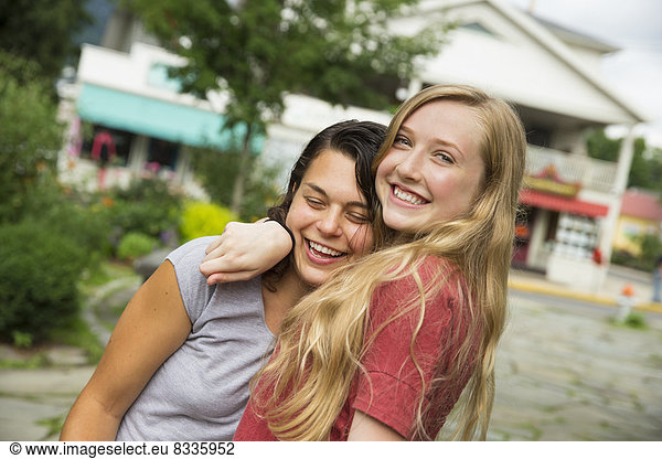 Two girls hugging and laughing.