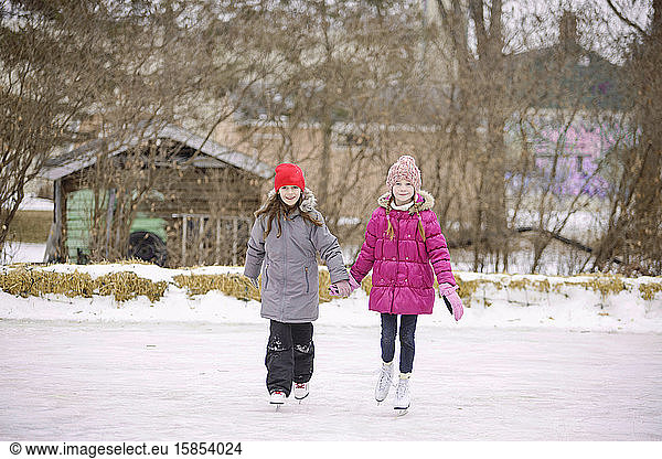 Two Girls Ice Skating Outdoors