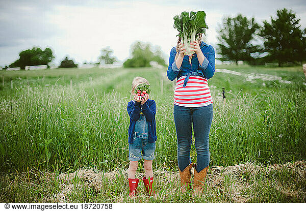 Two girls on a farm with produce as face