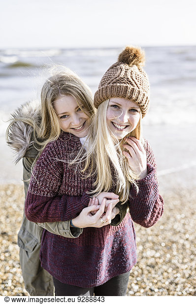 Two girls on the beach in winter.