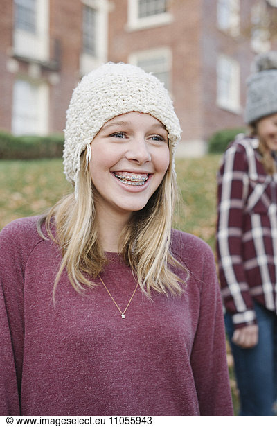 Two girls outdoors in woolly hats in autumn.