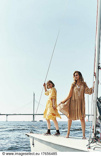 Two girls posing on yacht in summer