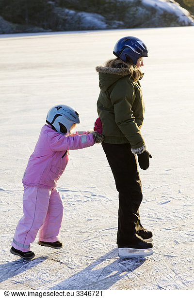 Two girls skating against the light  Sweden.