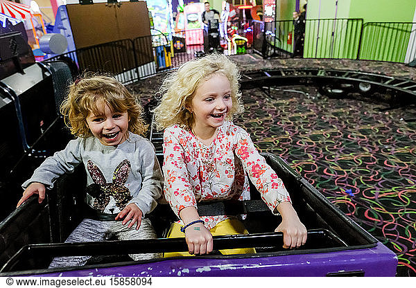 two girls smiling and laughing on rollercoaster having fun