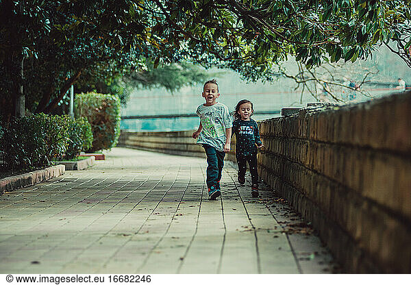 Two happy children run forward