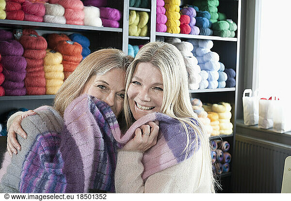 Two happy friends cuddling with scarf  Bavaria  Germany