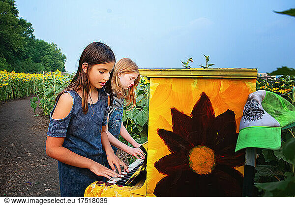 Two happy tween girls in a sunflower field.
