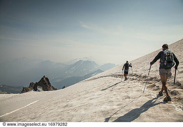 Two hikers descend Glacier Peak  a remote volcano in Washington.