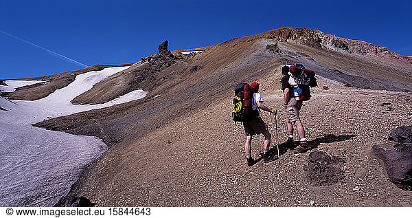 two hikers hiking up a mountain in Landmannalaugar