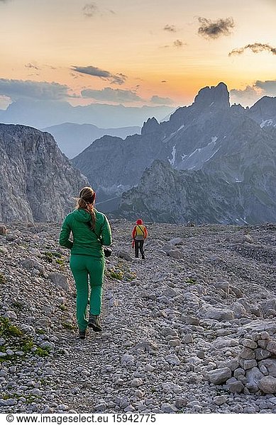 Two hikers in rocky alpine terrain  sunset over Gosaukamm with mountain peak Bischofsmütze  evening mood  Salzkammergut  Upper Austria  Austria  Europe