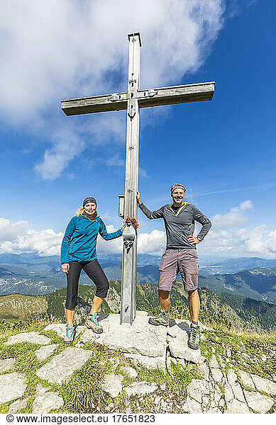 Two hikers posing by summit cross of Demeljoch mountain