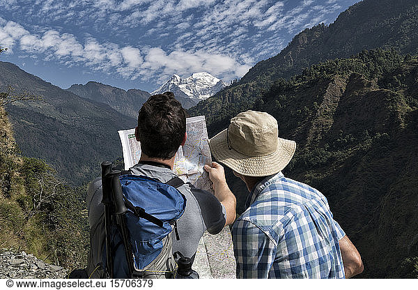 Two hikers reading map at Muri  Dhaulagiri Circuit Trek  Himalaya  Nepal