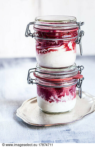 Two jars of homemade frozen yogurt with raspberry topping