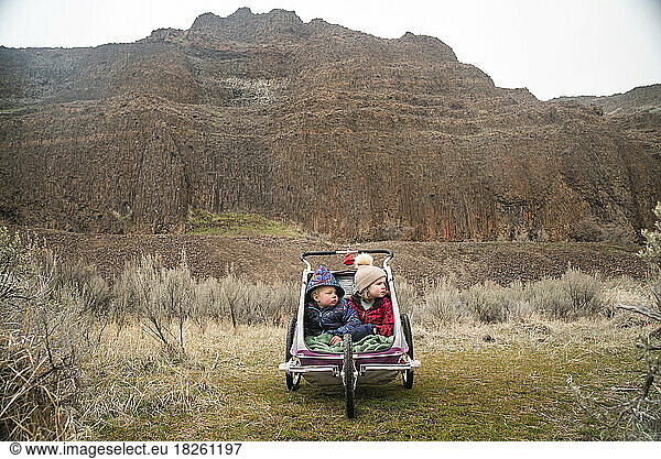 Two kids in a stroller in a desert canyon
