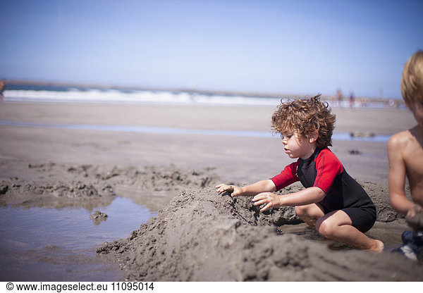 Two little boys building a sandcastle in sand on the beach  Viana do Castelo  Norte Region  Portugal