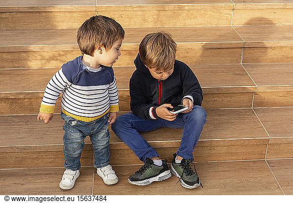 Two little boys looking at cell phone