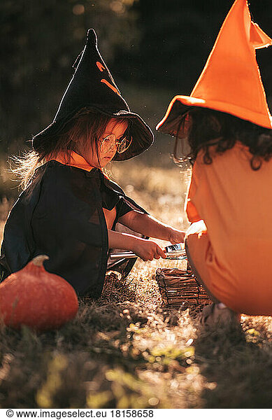 two little girls celebrate Halloween in nature pumpkin