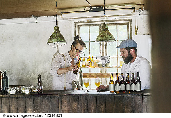 Two men drinking beer in local brewery
