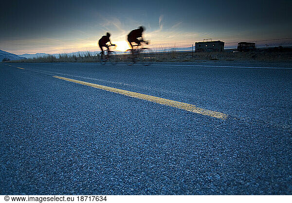 Two men ride on road bikes near Great Salt Lake.