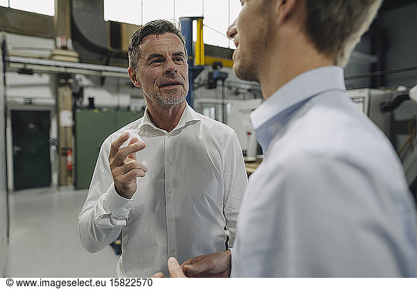 Two men talking in a factory