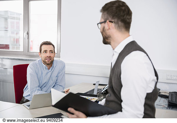 Two men talking office meeting planning