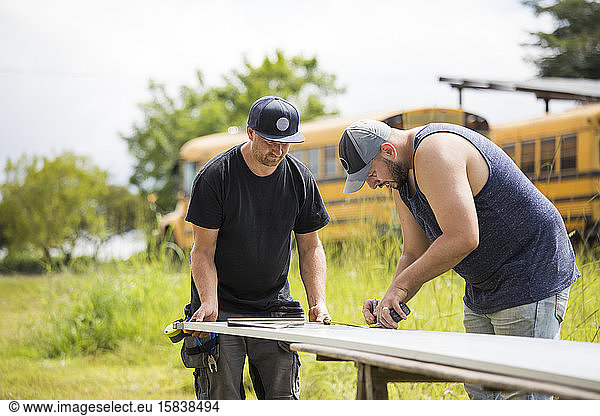 Two men working to assemble solar panels.