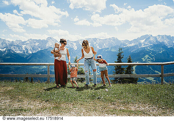 Two moms and kids playing in the mountains in summer