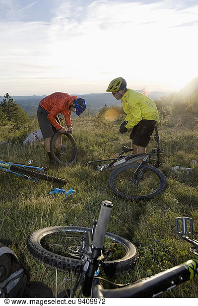 two mountain bikers repairing bicycle tyre  Vipava valley  Istria  Slovenia