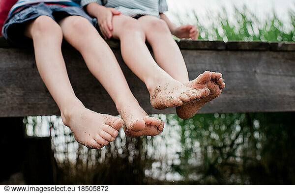 two pairs of kids sandy feet at the beach in summer