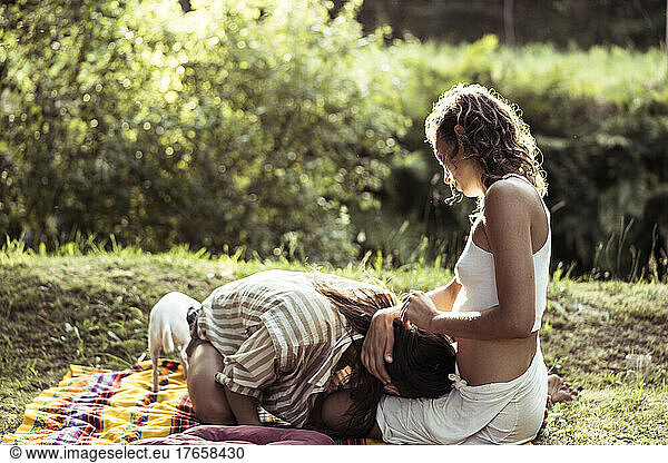 Two people having an intimate moment on a picnic rug with dog