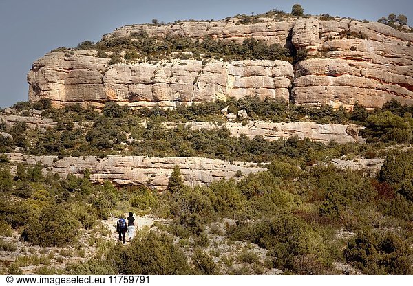 Two people make mountaineering in the Penya Galera way near Beceite village in Los Ports Mountains.