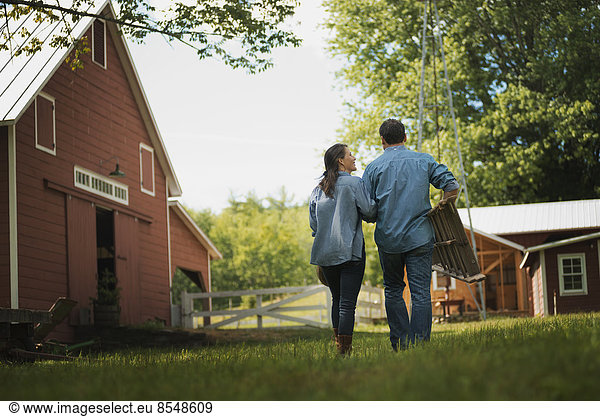Two people  man and woman in the yard of a traditional farm in the USA.