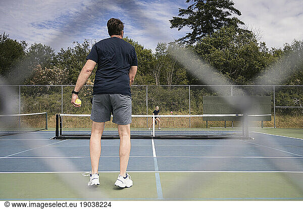 Two People Playing Pickleball on Sunny Day