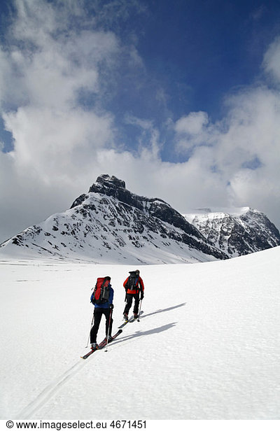 Two persons cross-country skiing on mountain