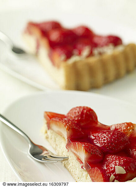 Two pieces of strawberry cake on dishes