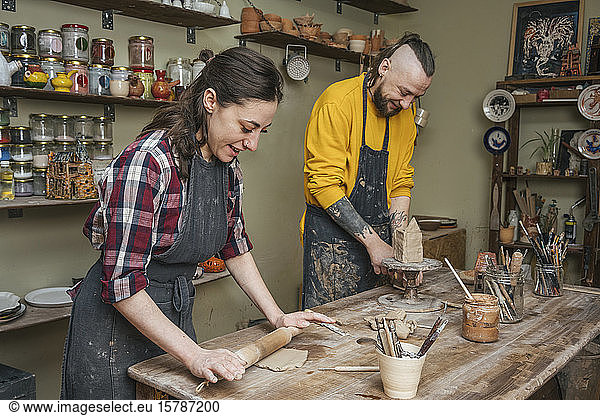 Two potters working together in workshop