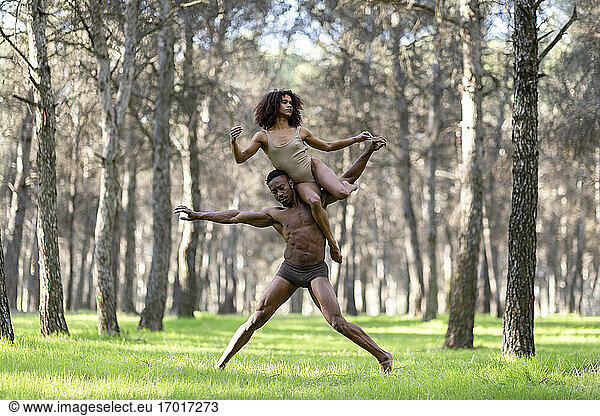 Two professional dancers performing in underwear in middle of forest