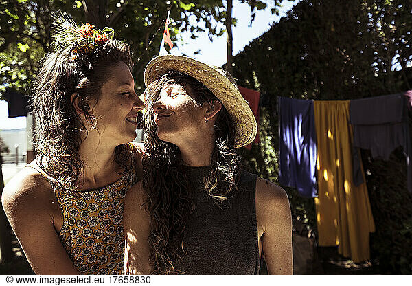 Two queer women intimately hug in summer campsite