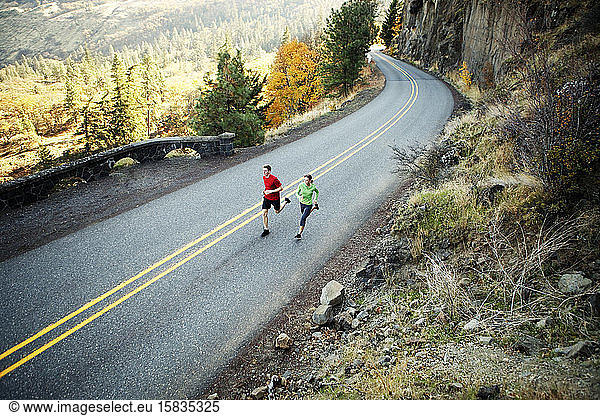 Two runners in their mid 20s running along scenic road in Rowena