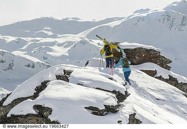 Two skiers walking on a ridge in the French Alps.