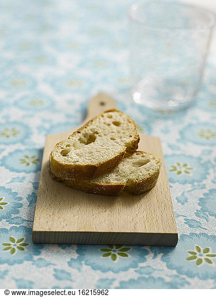 Two slices of baguette on wooden board  close-up