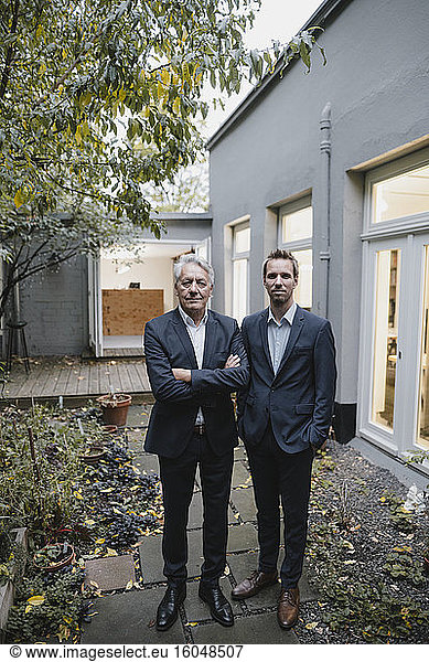 Two successful businessmen standing on backyard of their office