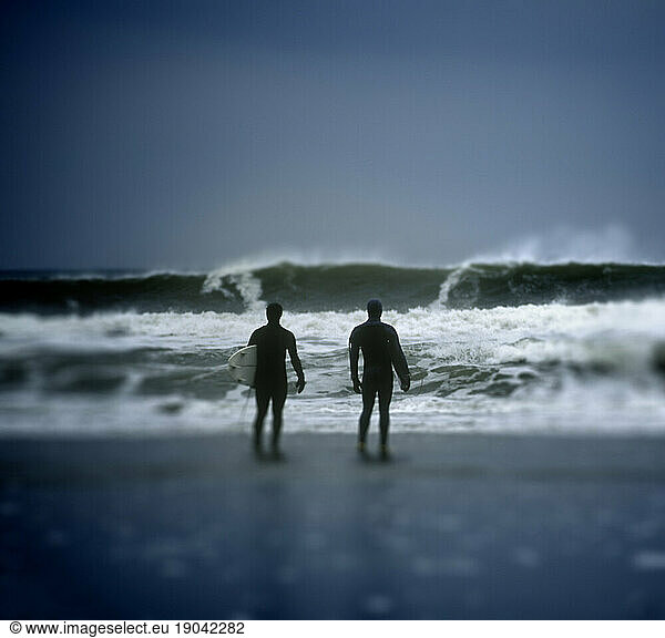 Two surfers scout the break along Higgins Beach  Maine. (selective focus)