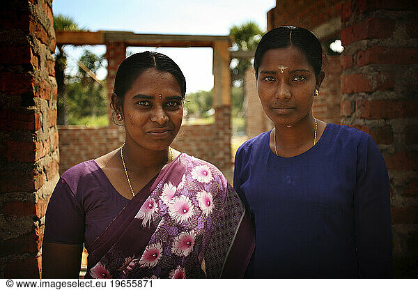 Two teachers posing outside of their tsunami-ruined school. Kalmunai  Sri Lanka.